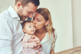 Eltern küssen Baby
