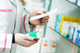 Apotheker prüft Rezept und hat eine Arzneimittel in der Hand.
