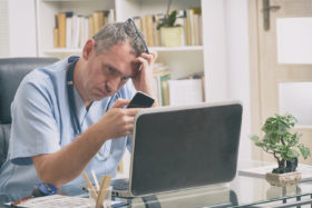 Arzt sitzt vor dem Computer
