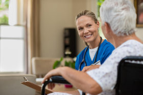 Ärztin beim Hausbesuch im Gespräch mit einer Seniorin