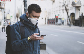 Mann mit Maske und Handy